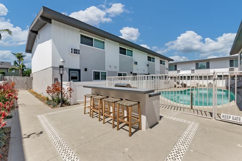 a patio with a bar and a pool in front of a building